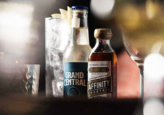 Bottles of Grand Central and Affinity beverages with ice bucket on blurred background.