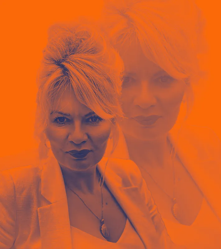 Blonde woman in blazer with pendant necklace