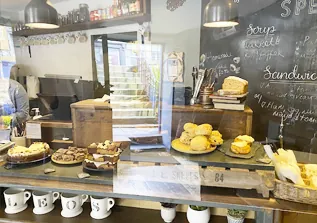 Bakery counter with scones, pastries and chalkboard menu in café interior