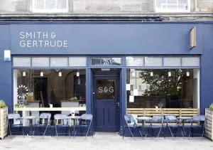 Navy storefront of Smith & Gertrude with outdoor seating and large glass windows.