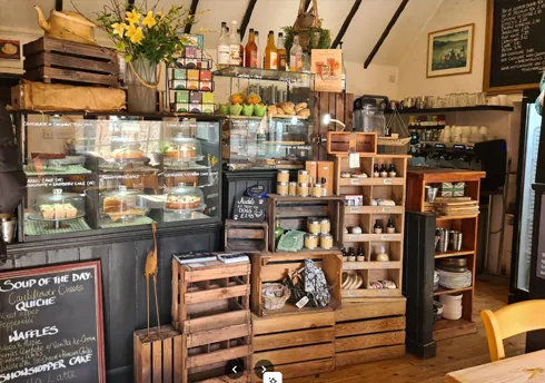 Rustic cafe counter with homemade cakes, fresh bakes, preserves and local produce on display